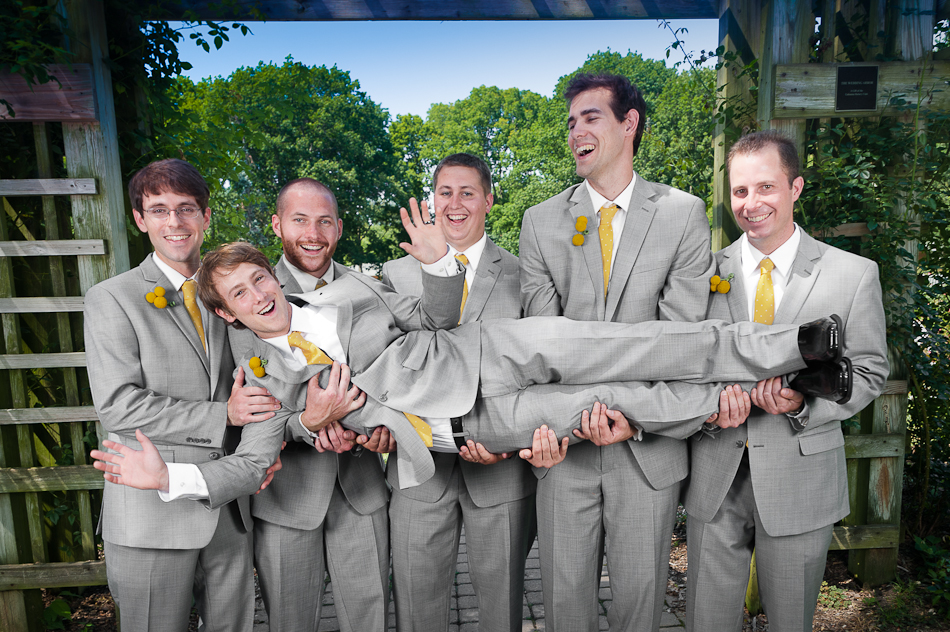 Funny wedding photo of groom carried by wedding party