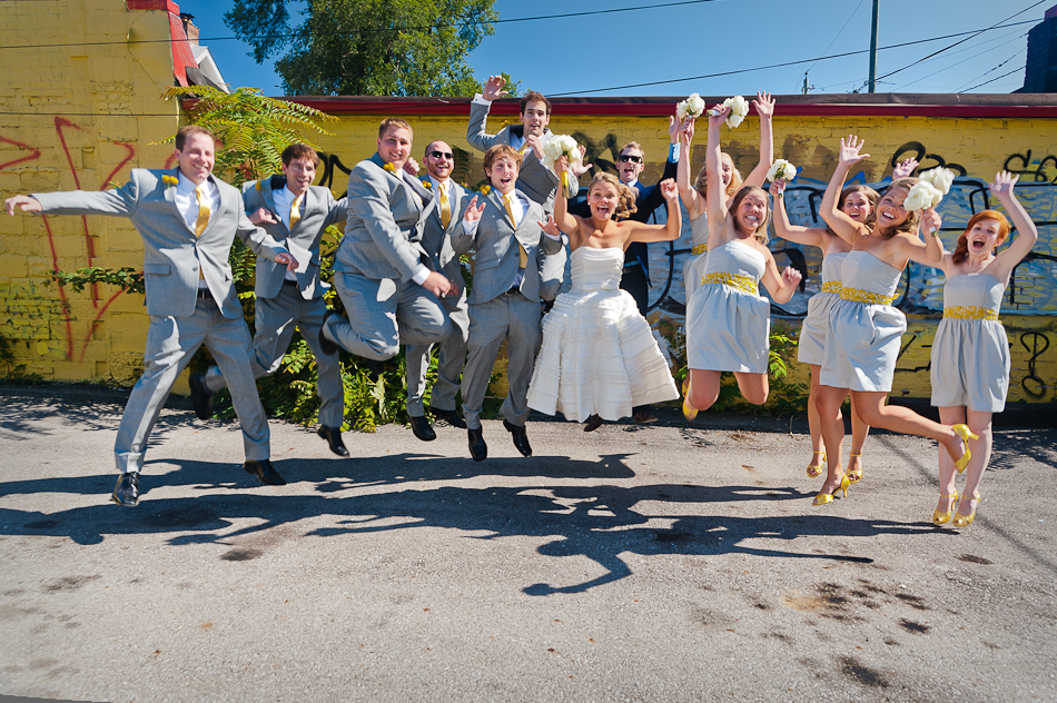 wedding party jumping mid air in front of columbus graffiti wall