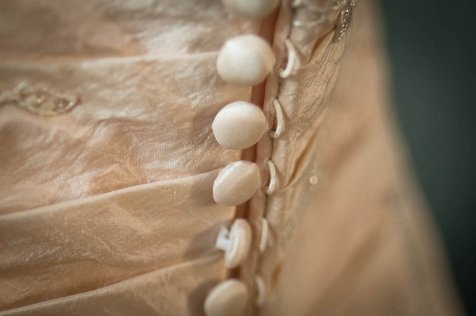 Detailed view of wedding dress closure, buttons with loops and pleated fabric