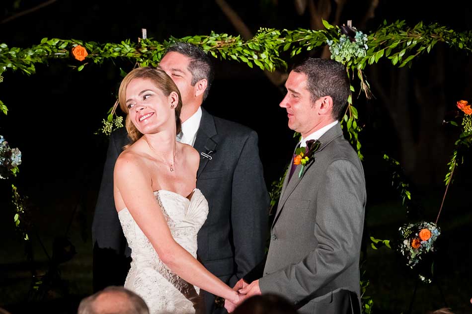 Night time outside ceremony with bride looking over shoulder