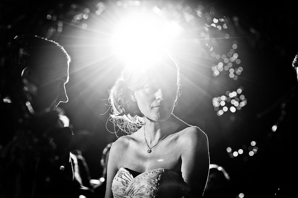 Night time photo with lens flare of bride during ceremony