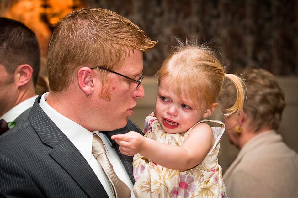 Father comforts crying daughter during wedding reception