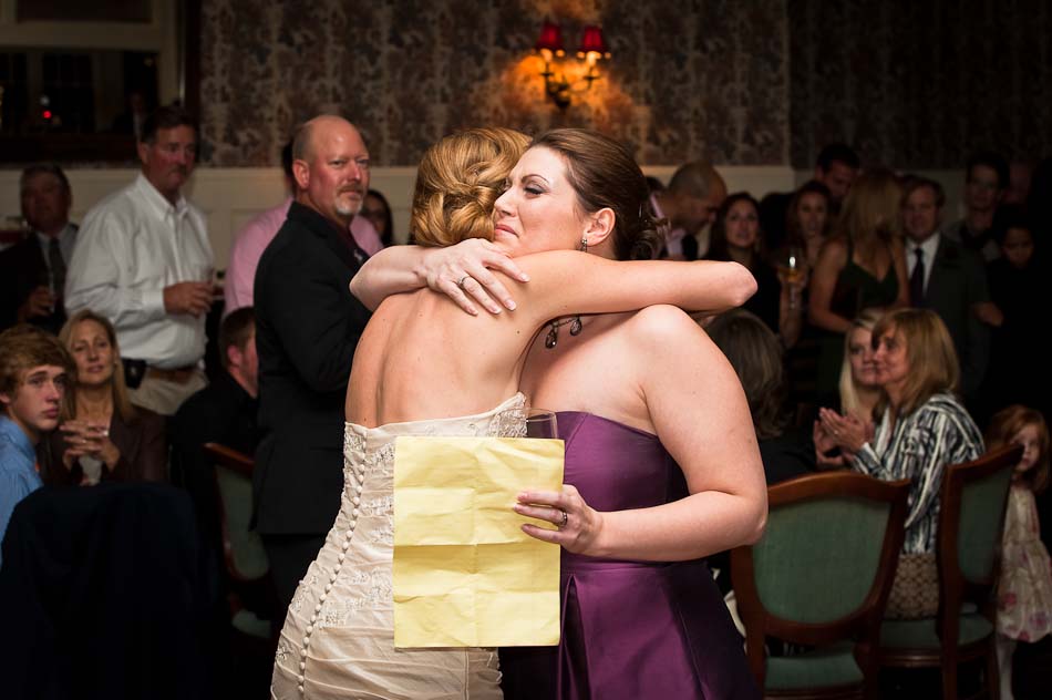 Maid of honor and bride hugging after she recites a heartfelt speech at wedding reception