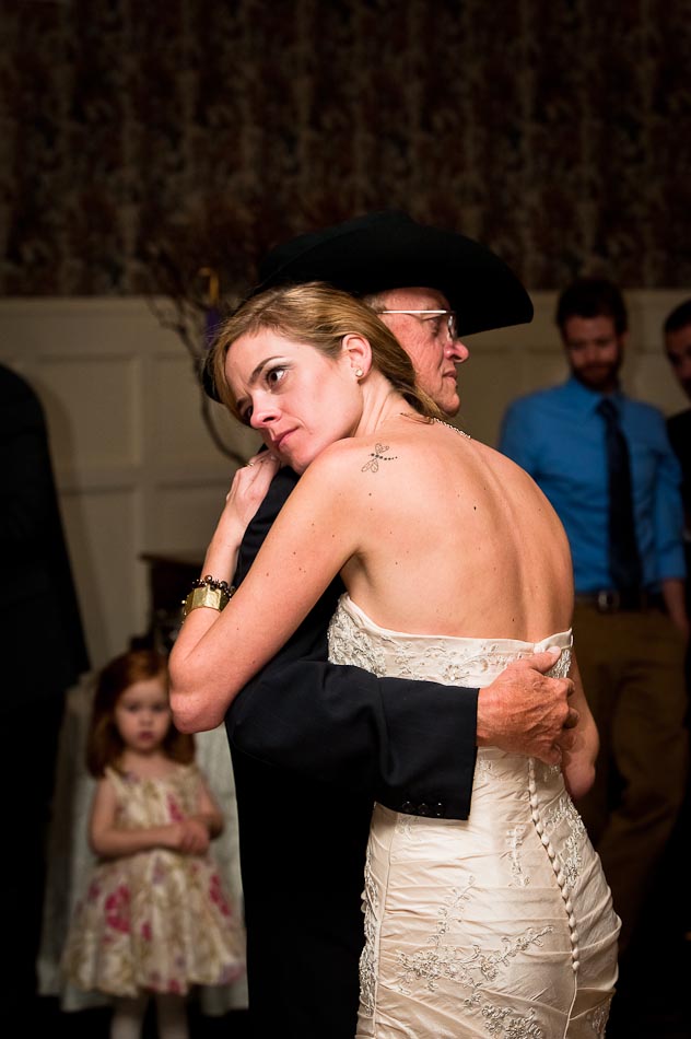 Father in black cowboy hat dances with daughter during wedding reception