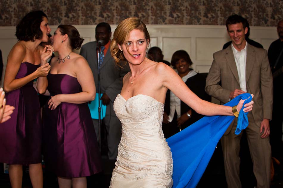 Sexy bride dances with lucky college sweatshirt during wedding reception at Green  Pastures
