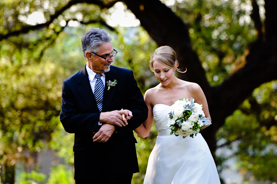 father walking daughter to wedding ceremony outside trees