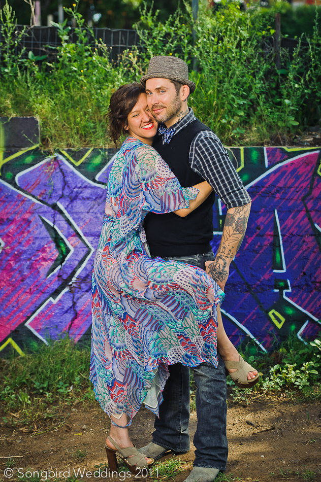 Couple hugging in front of east austin graffiti wall