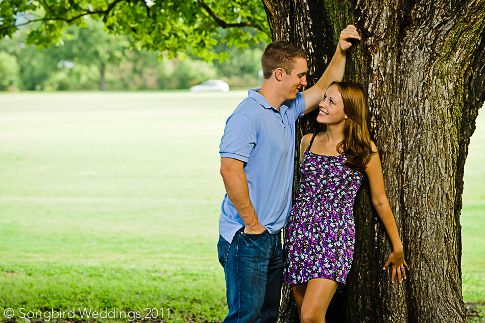 Couple standing by tree during engagement photoshoot in park