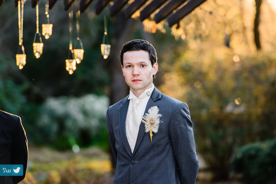 groom with peacock feather boutonniere in austin texas winter wedding