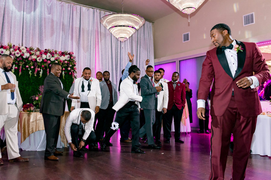 Black groom garter toss with purple uplighting by austin wedding photographers