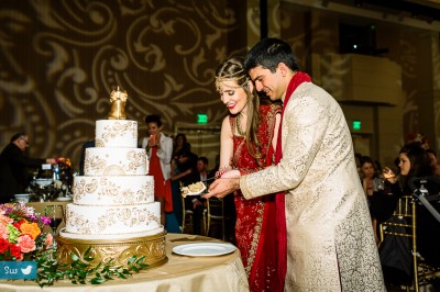 Hindu Indian wedding couple at reception cutting Mehndi designed cake