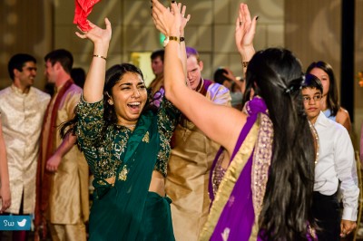 Indian wedding reception, women dancing wearing sarees