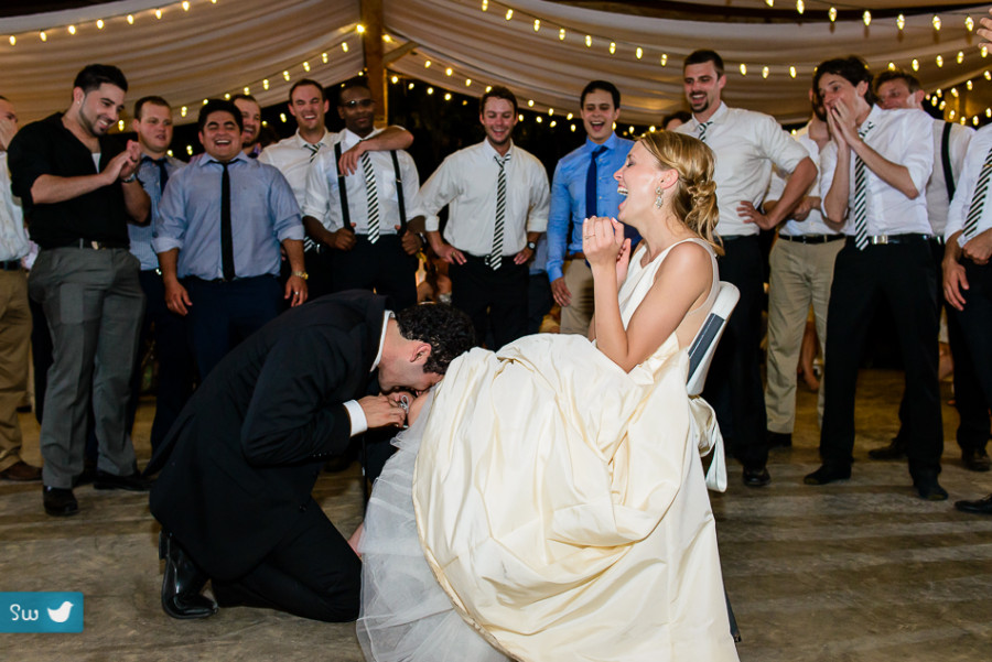 groom taking off the garter by Austin Wedding Photographers