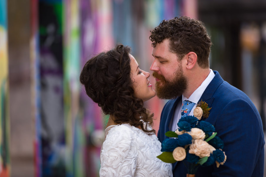 groom-bride-Austin-Wedding-Photographers-portraits-downtown-tx-mural-graffiti-colorful-kiss