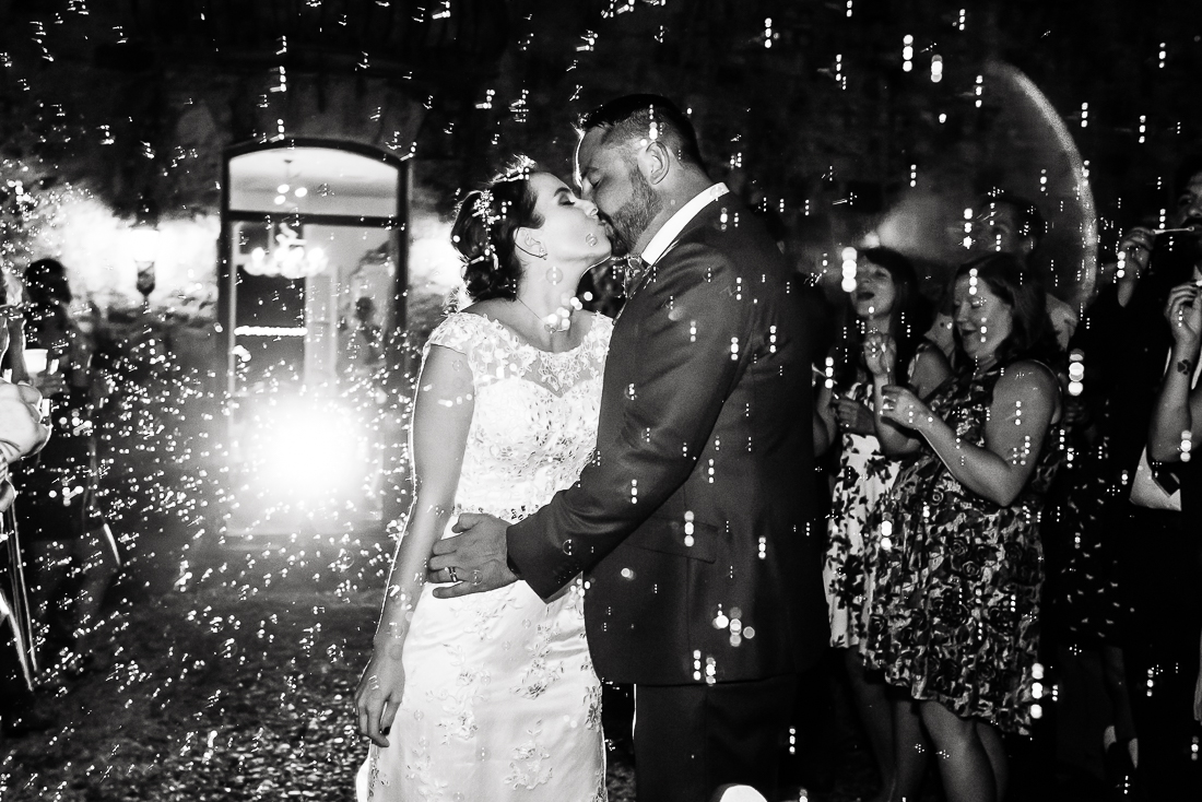 Dramatic bubble exit departure groom kiss bride lights austin wedding photographers